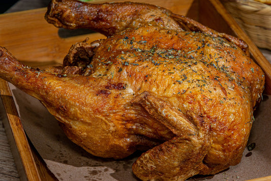 Foto apetitosa de frango assado inteiro em destaque, ilustrando a receita apresentada no blog Granuz